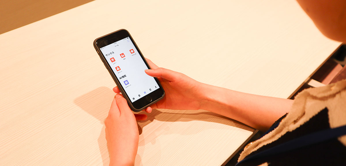 スマートフォンでWowTalkを操作するNAAリテイリングの従業員の方の手元